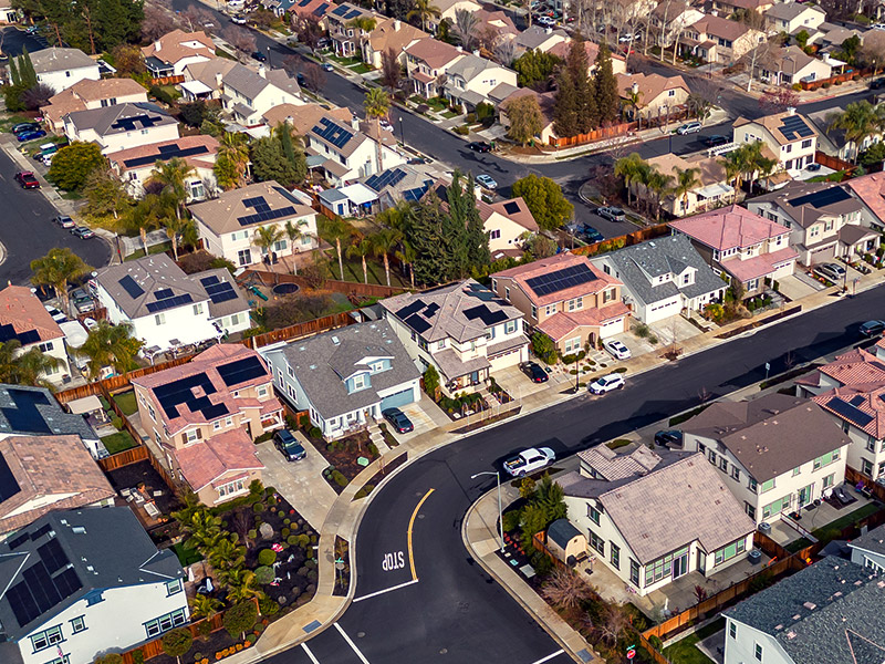 Neighborhood looked from the sky with multiple houses with solar panels on the rooftop